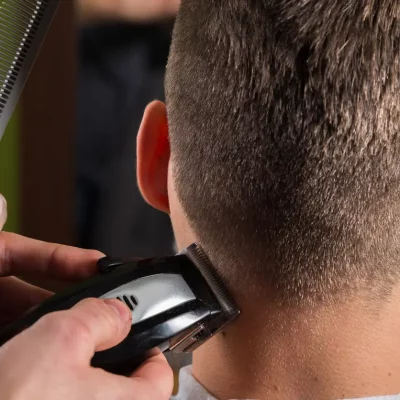 Hairdresser cutting clients hair with an electric hair clipper Hairdresser cutting clients hair with an electric hair clipper at beauty salon